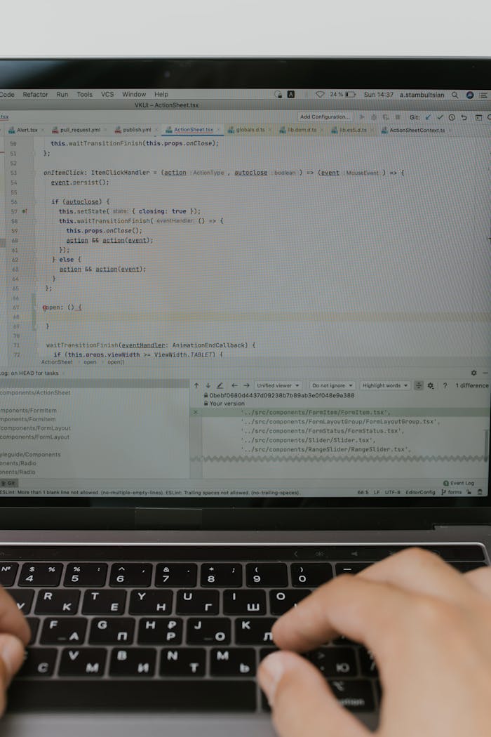 Close-up of hands typing code on a laptop, illustrating software development and coding.